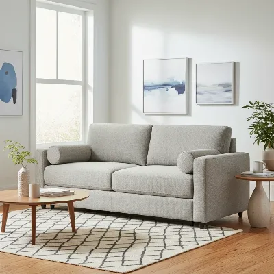 A stylish modern sleeper sofa in a contemporary living room setting, showcasing its dual function as a comfortable seating area and a discreet guest bed.